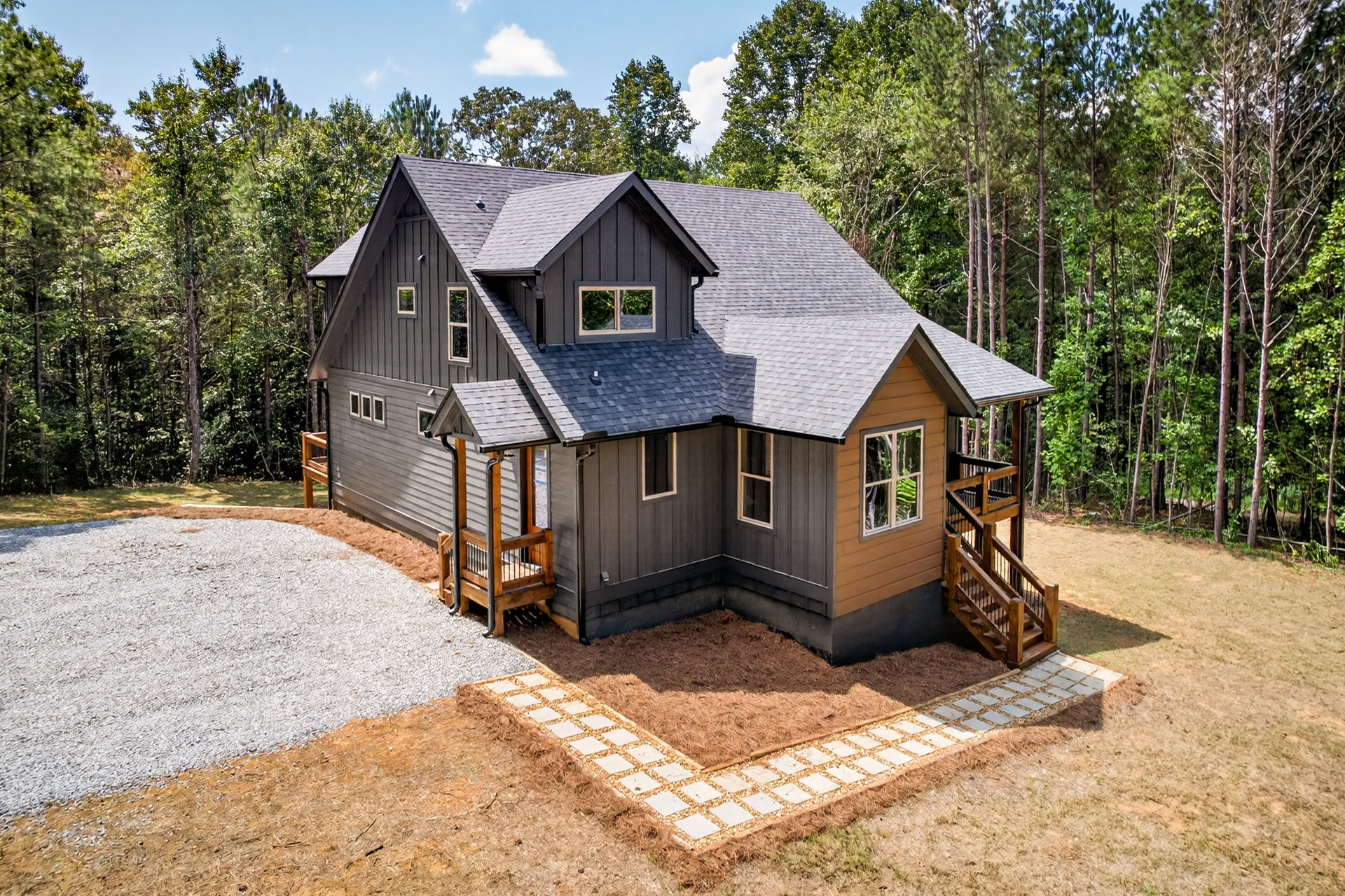 Front-side of the home with gravel parking and a stone walkway at 824 Banks Rd, Ellijay, GA