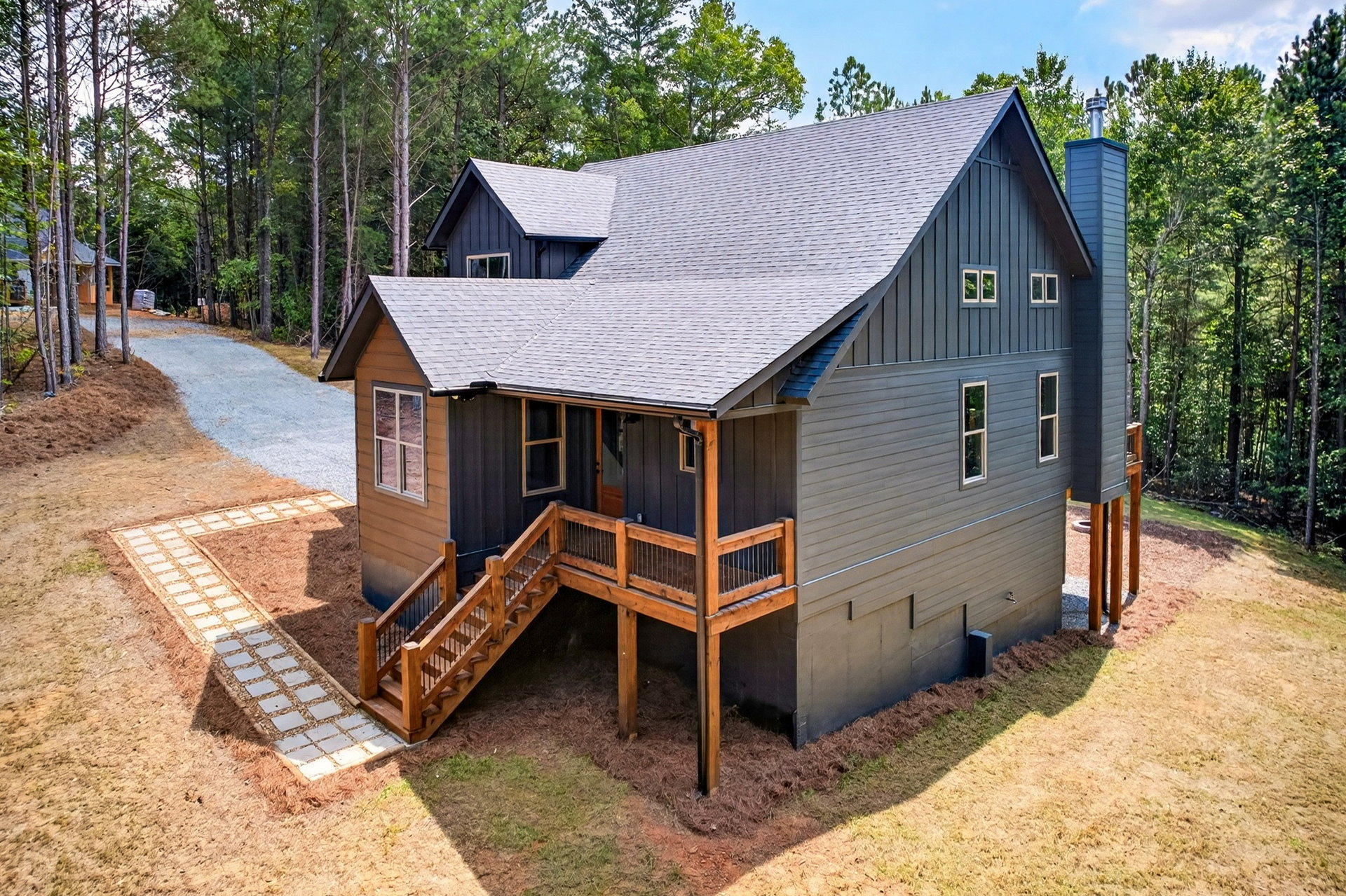 Side of the home showing the wood deck and stone path at 824 Banks Rd, Ellijay, GA