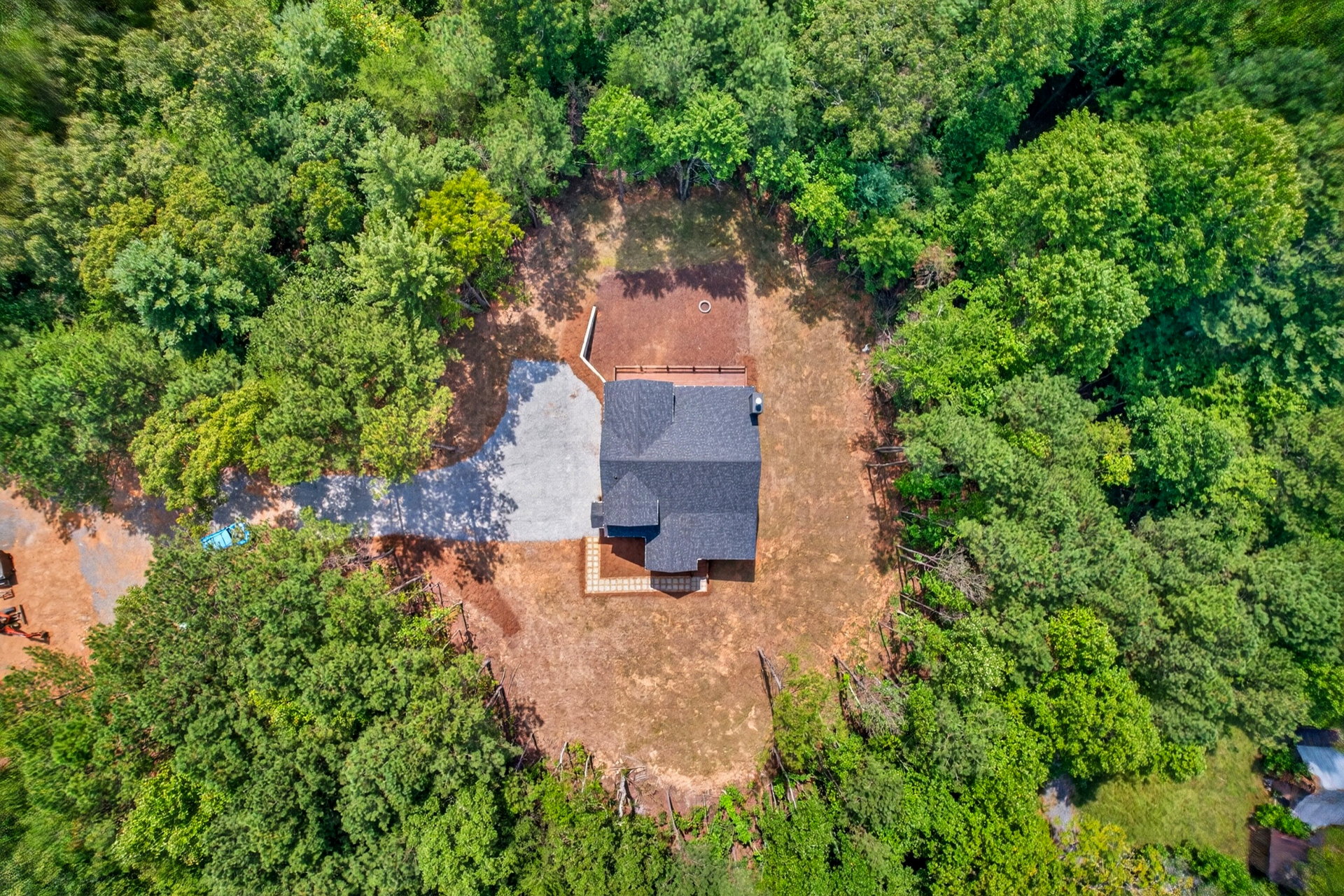 Aerial view of the home and driveway in a forest clearing at 824 Banks Rd, Ellijay, GA