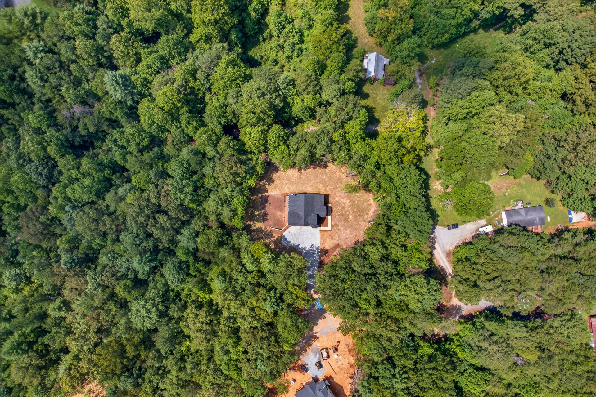 High aerial of the home along a winding drive through trees at 824 Banks Rd, Ellijay, GA