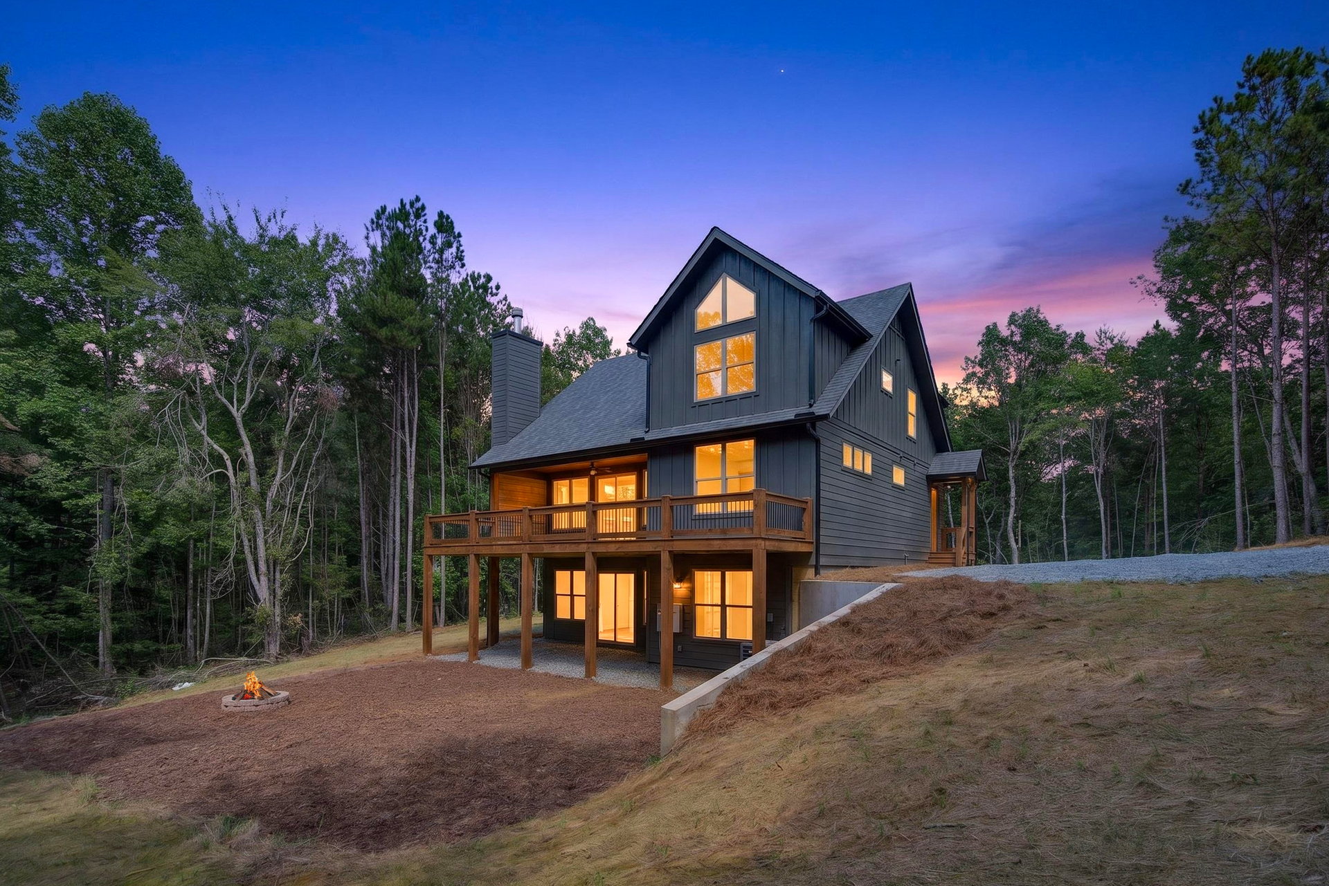 Dusk side-rear view of the multi-level deck on the sloped lot at 824 Banks Rd, Ellijay, GA