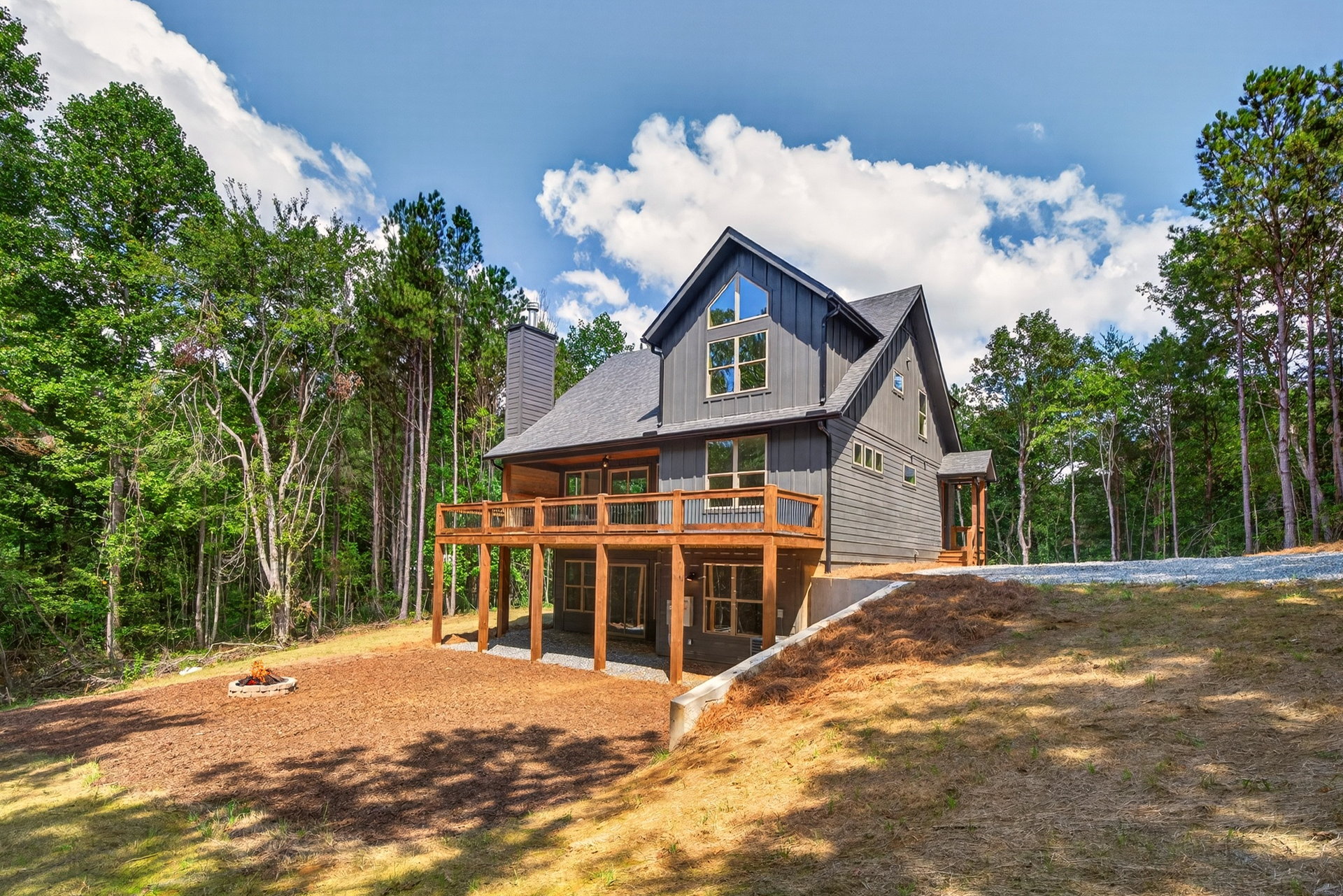 Rear of the home with two-story wood deck and fire pit at 824 Banks Rd, Ellijay, GA