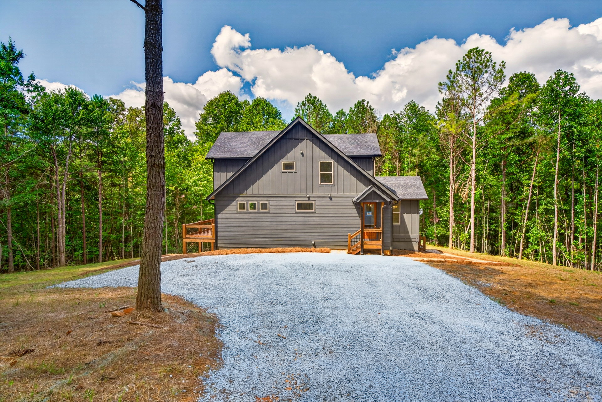 Front of the dark gray home from the gravel driveway at 824 Banks Rd, Ellijay, GA