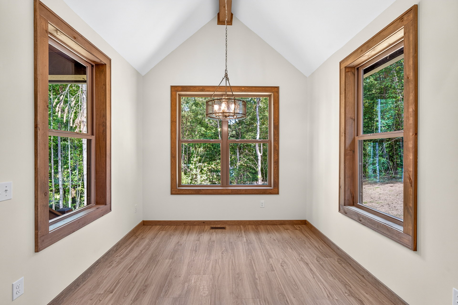 Interior room with vaulted ceiling, chandelier, and forest-facing windows at 824 Banks Rd, Ellijay, GA