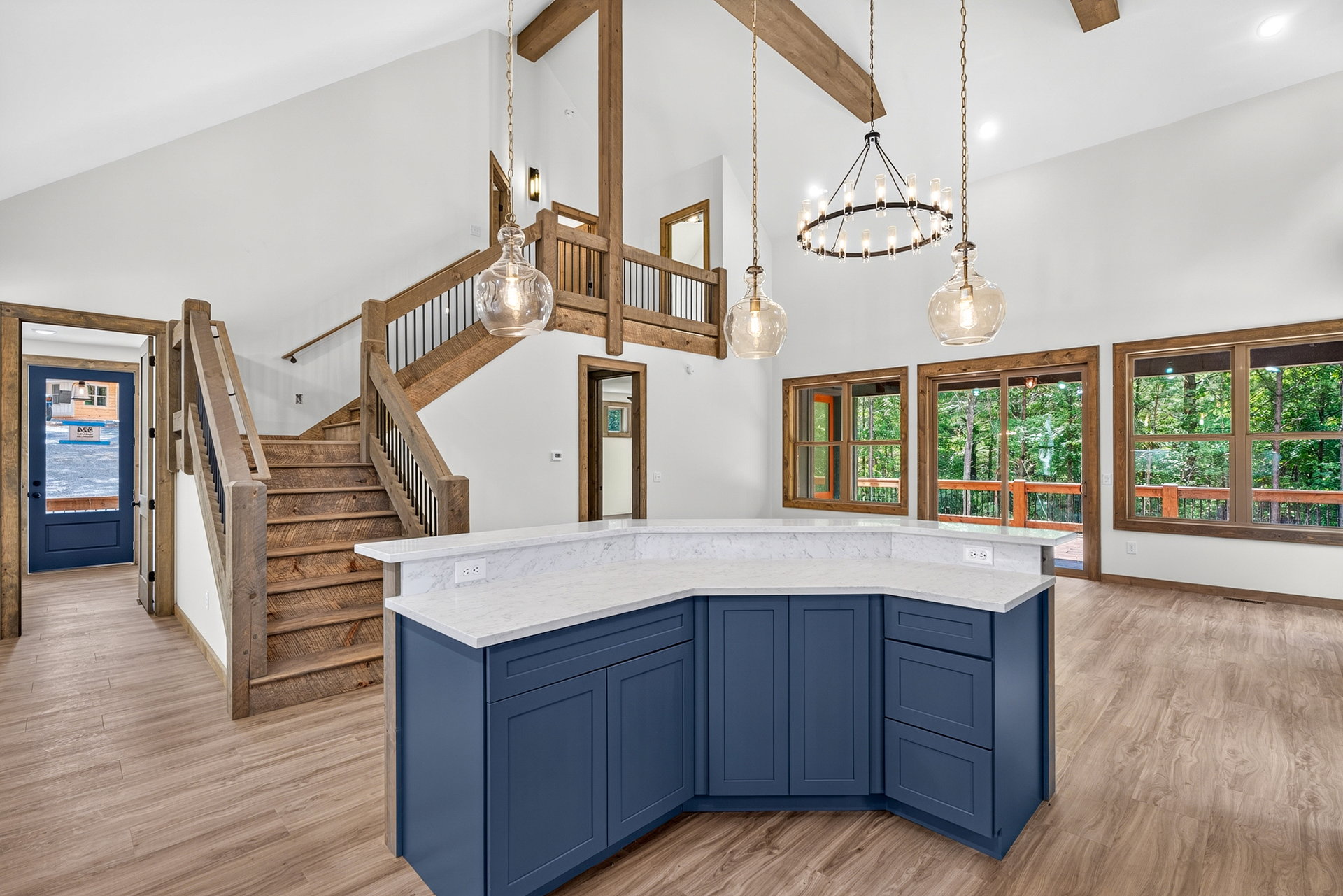 Living area from the kitchen island toward stairs and chandelier at 824 Banks Rd, Ellijay, GA