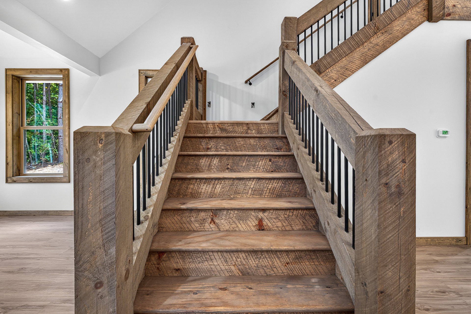 Interior wood staircase with dark metal railing at 824 Banks Rd, Ellijay, GA