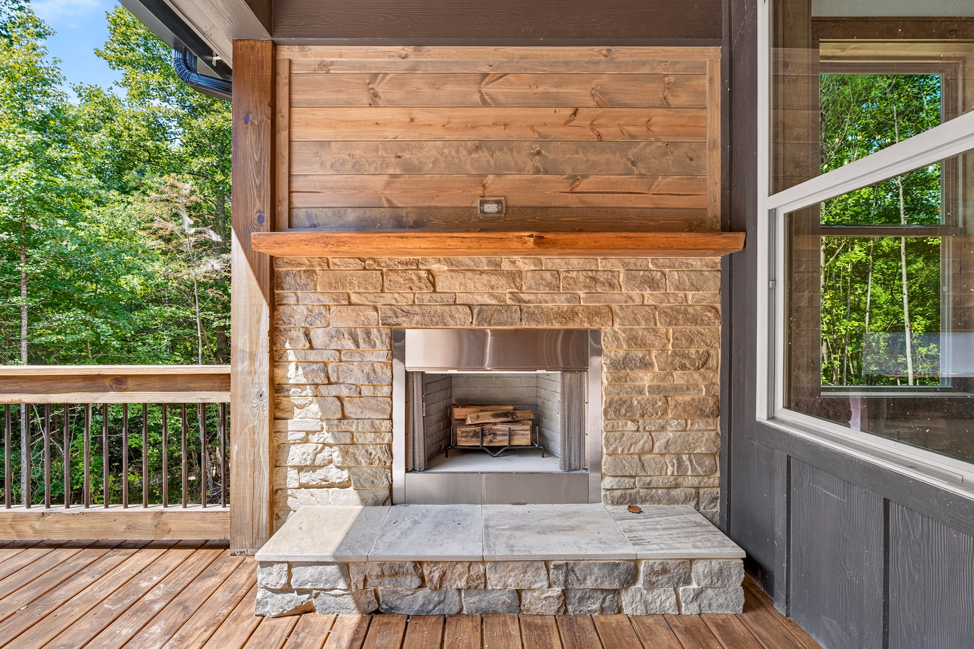 Close view of the stone outdoor fireplace on the deck at 824 Banks Rd, Ellijay, GA