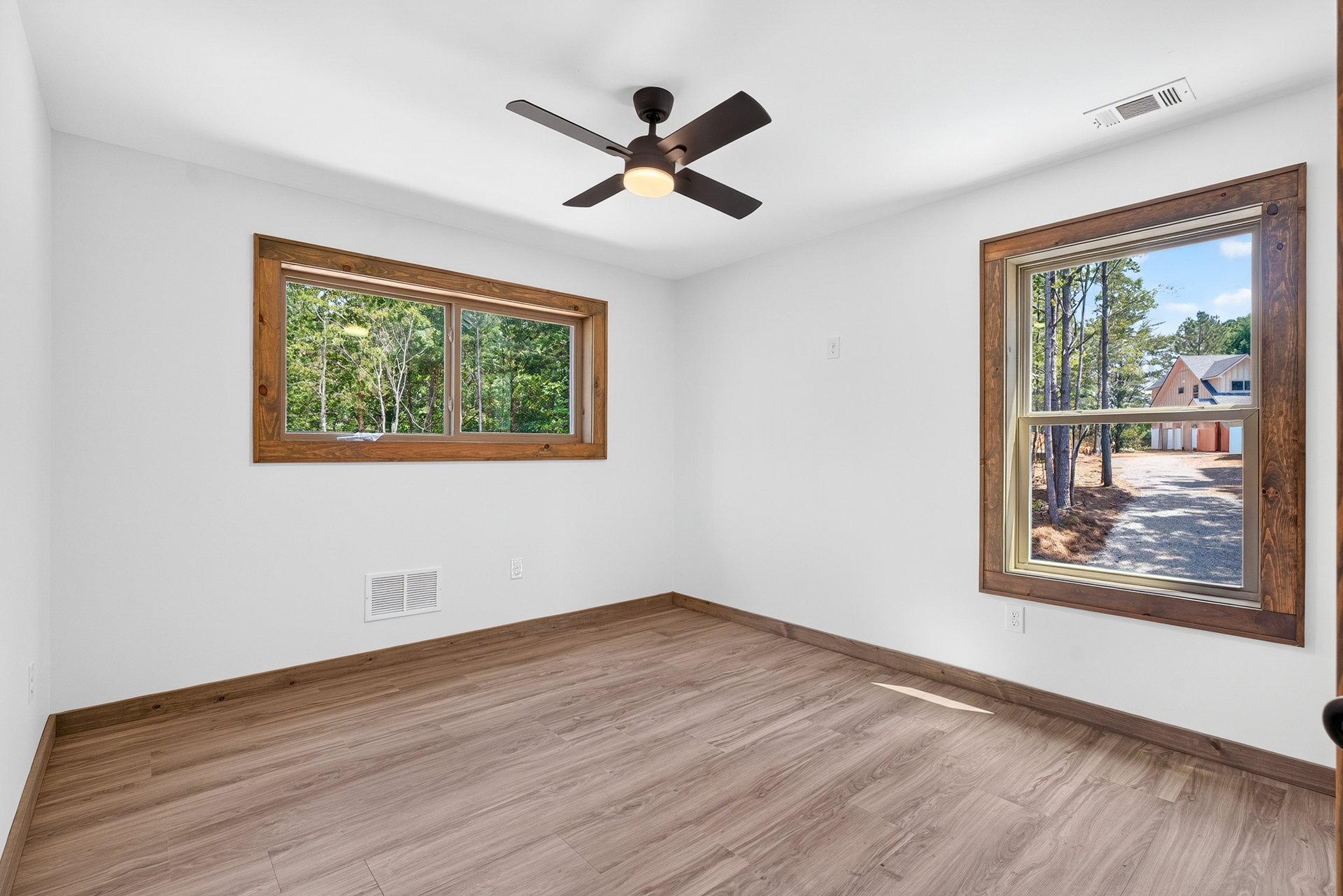 Bedroom with two wood-trimmed windows and a ceiling fan at 824 Banks Rd, Ellijay, GA