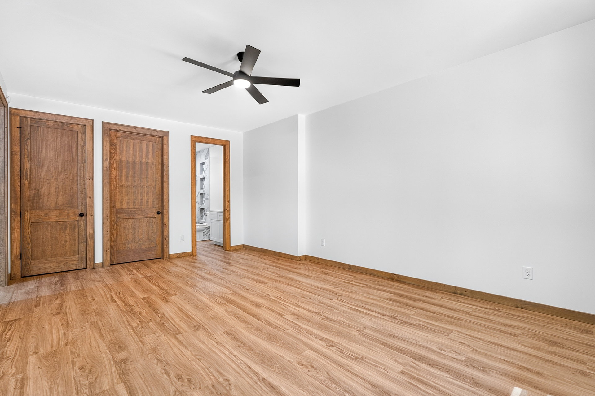 Empty bedroom with two wood doors and a ceiling fan at 824 Banks Rd, Ellijay, GA