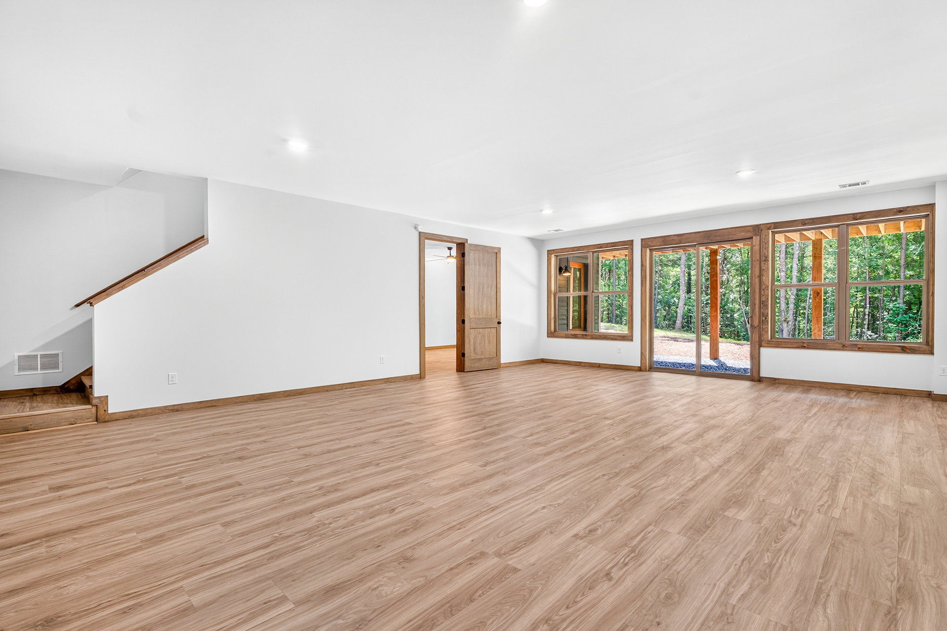 Lower-level room showing the stair base and wood doors at 824 Banks Rd, Ellijay, GA