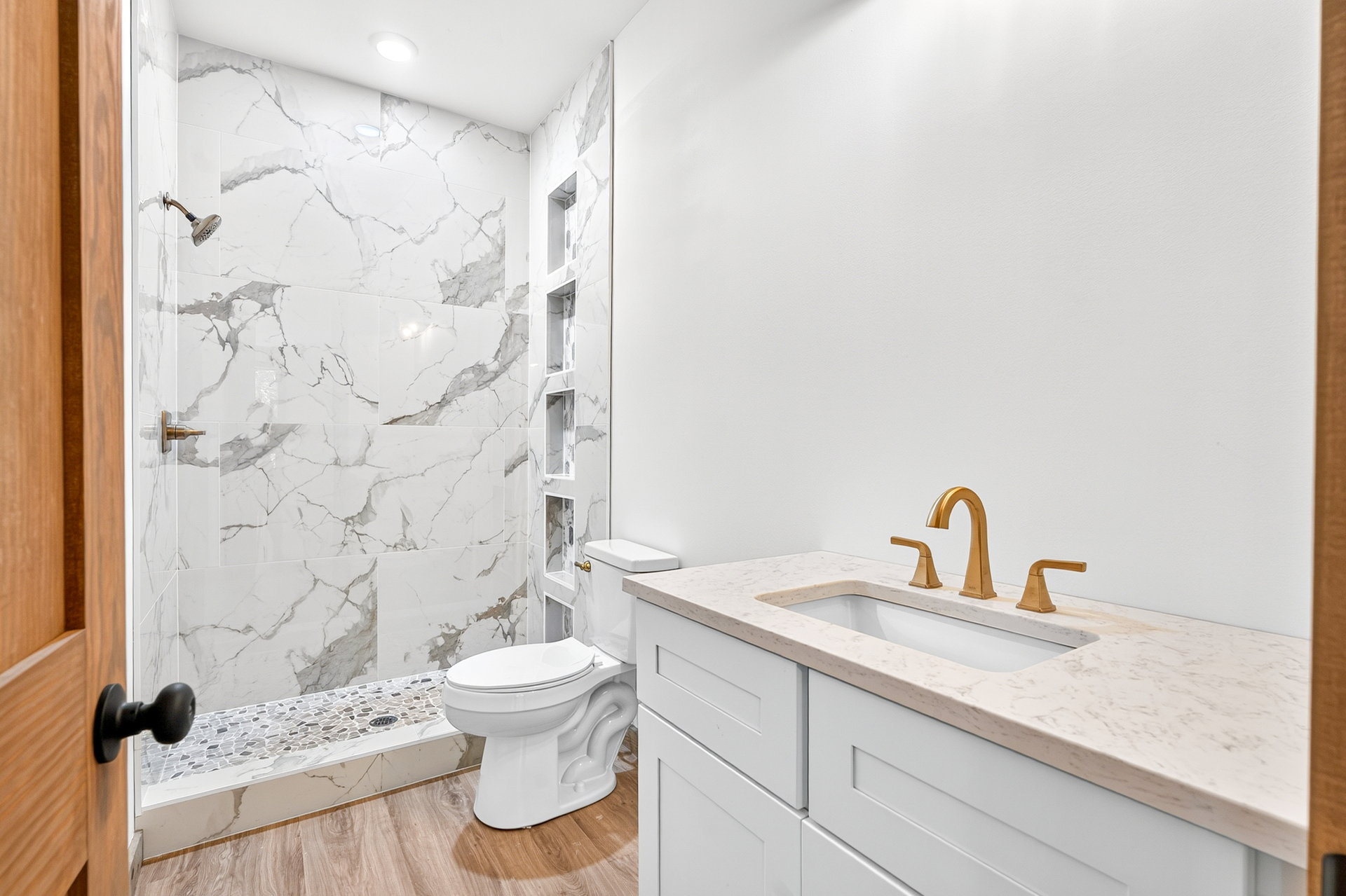 Bath with white vanity, gold faucet, toilet, and marble-look shower at 824 Banks Rd, Ellijay, GA