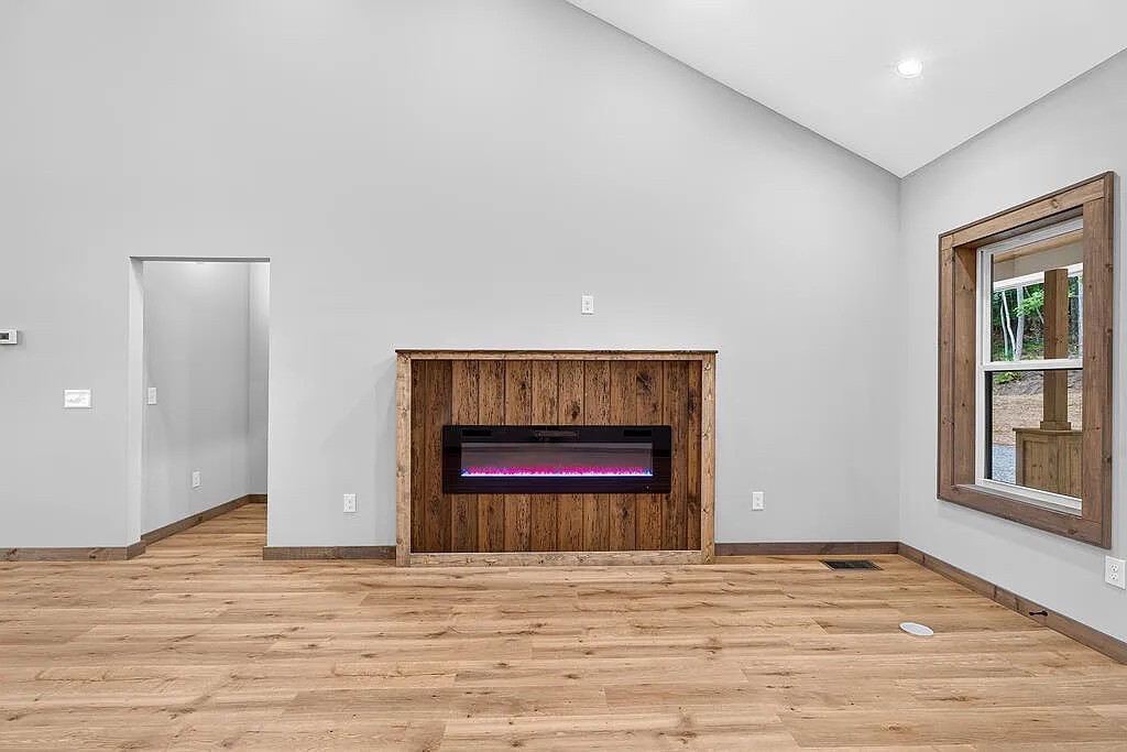 Living room with a wood-surround fireplace and a wood-framed window to the porch