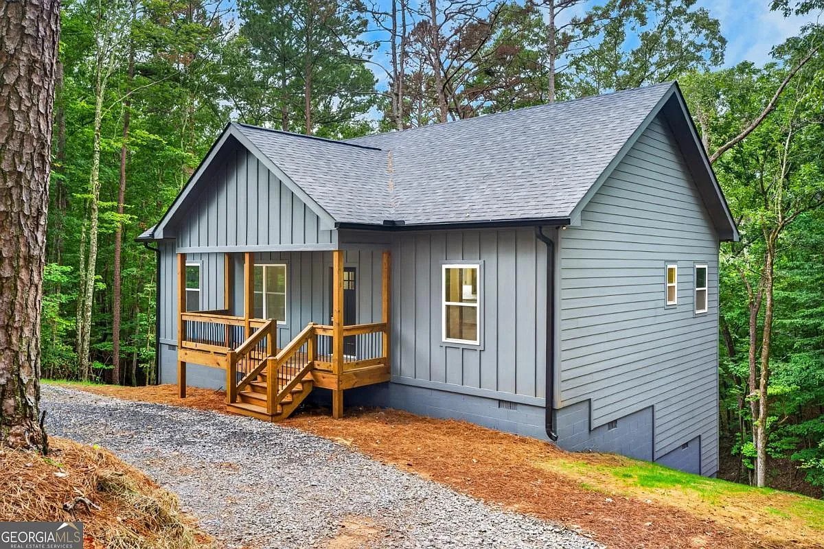 Front three-quarter of the grey-blue home with a wood porch at 579 Julep Circle, Ellijay, GA