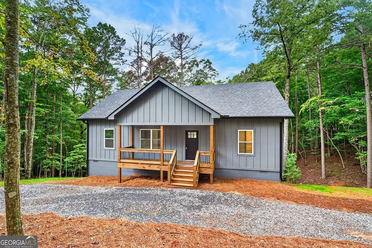 Front exterior of the grey board-and-batten home with wood porch at 579 Julep Circle, Ellijay, GA