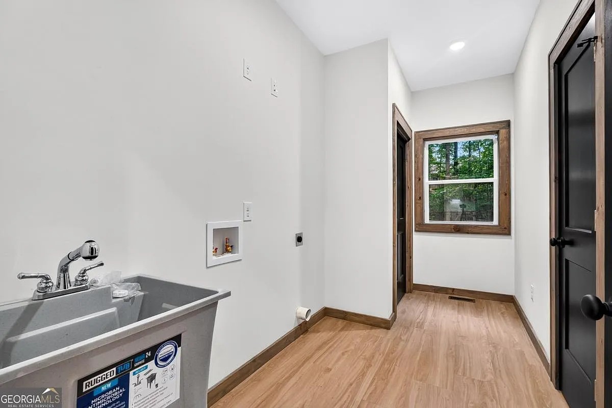 Laundry room with utility sink and wood-trimmed window at 579 Julep Circle, Ellijay, GA