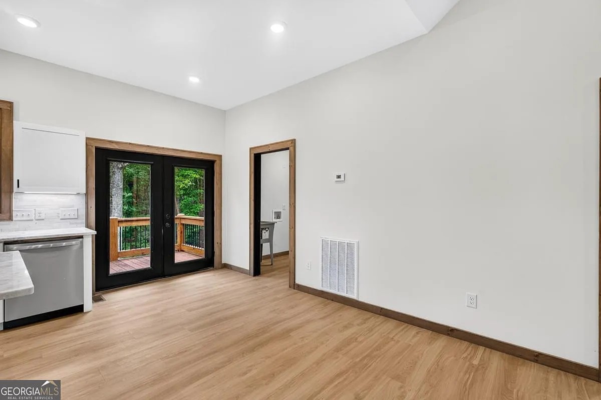 Kitchen and living area with glass doors opening to a wood deck